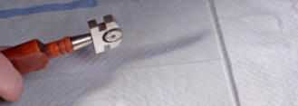 man cutting a sheet of glass